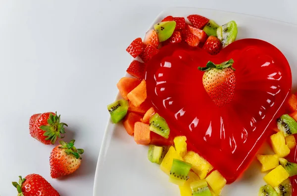 Truskawkowy kształt serca żelatyny z owocami na białym talerzu. Walentynki. — Zdjęcie stockowe
