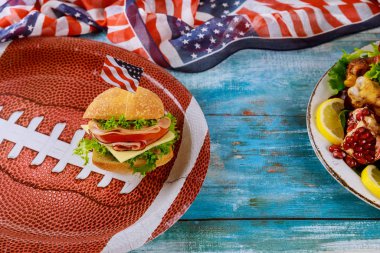 Amerikan futbolu yemeği mavi ahşap arka planda.