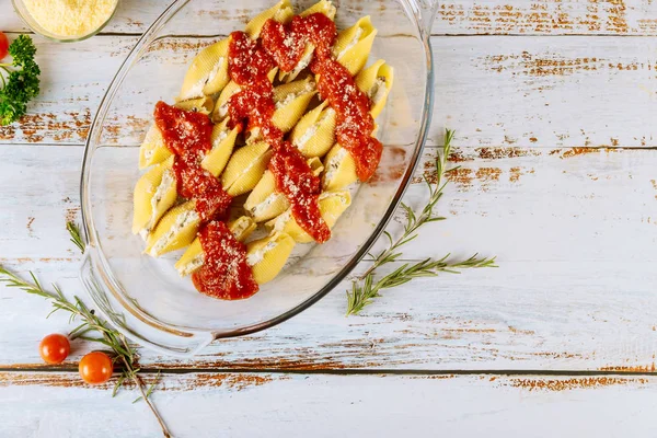 Staffed jumbo shells pasta with tomato sauce in glass baking pan. — Stock Photo, Image