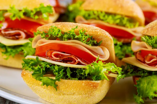 Красочные сэндвичи на белой тарелке на деревянном фоне. Закрыть . — стоковое фото