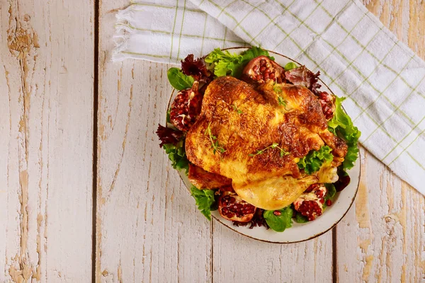 Pollo asado entero en plato con ensalada y granada . —  Fotos de Stock