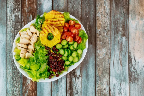 Fitness nutrition salad on wooden background.