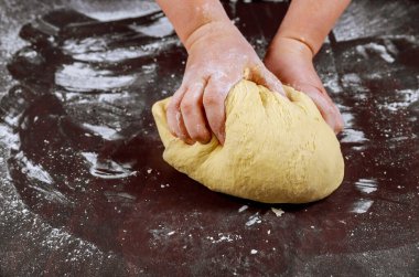 Kadın ekmek yapmak için elleriyle yoğuruyor..