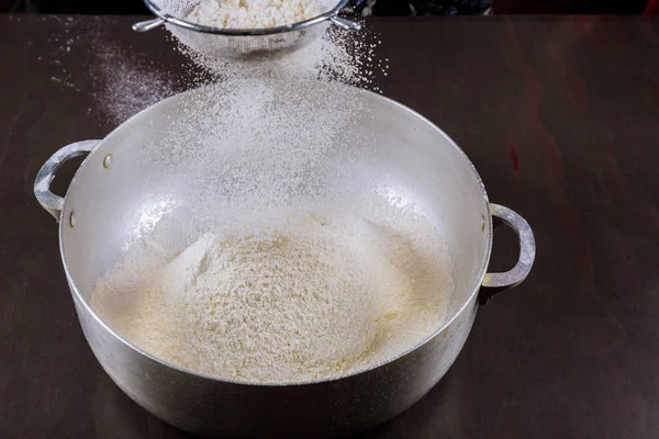 Sifting flour with sieve in metalic pan. — Stock Photo, Image