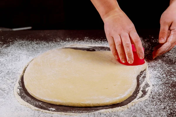 Женщина вырезает круги из теста для приготовления булочек, пончиков . — стоковое фото