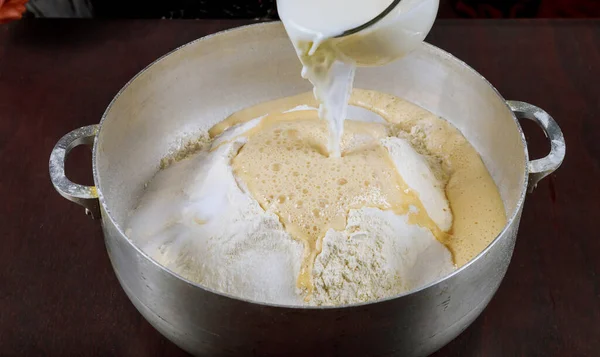 Выливание молока на тесто для приготовления пончиков .. — стоковое фото