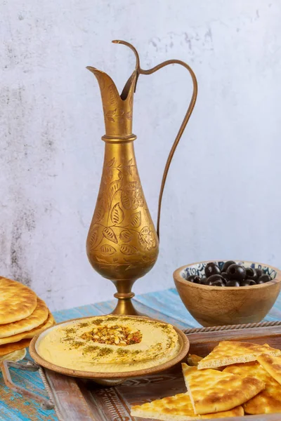 Mesa de fiesta turca con hummus, pan y jarra de cobre . — Foto de Stock