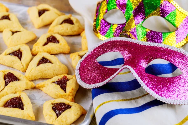 Biscoitos Hamantaschen na assadeira com tallit e máscara . — Fotografia de Stock
