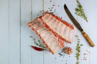 Raw pork ribs with herbs, garlic and pepper on white background.