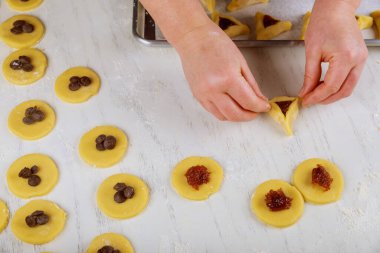 Woman making hamentaschen cookies for Purim. Jewish holiday concept,