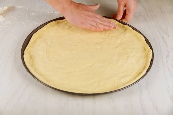 Fresh raw pizza dough in oven pan. — Stock Photo, Image