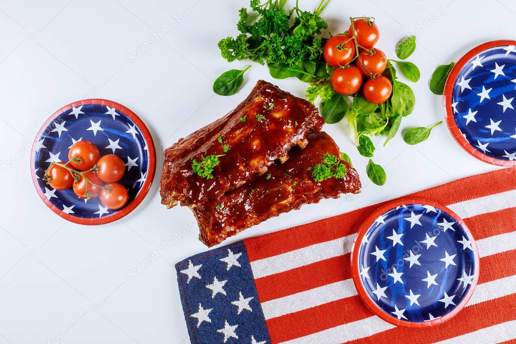 Party table with BBQ ribs and american flag.
