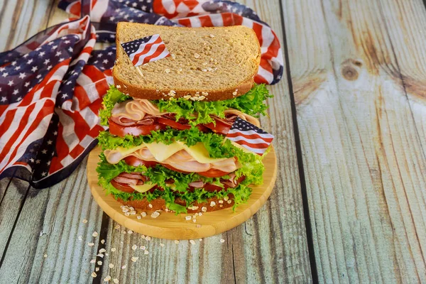 ハムと大きなサンドイッチ,アメリカの休日のテーブルのためのチーズとトマト. — ストック写真