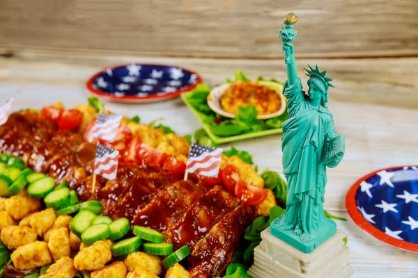 Delicious american food on party table with Statue of Liberty.