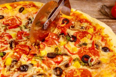 Tahta arka planda pizza kesiyorum. Kapat..