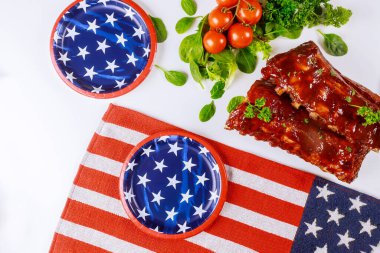 Party table with tater BBQ baby back ribs for Independence Day. clipart