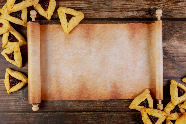 Rotolo di papiro con biscotti Purim su sfondo di legno . — Foto Stock