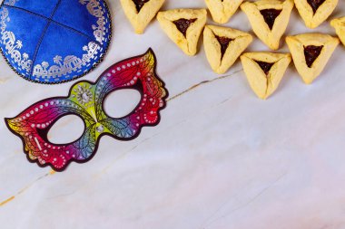 Purim background with mask, kippa and cookies.