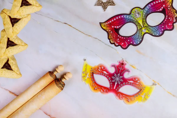 Purim abstract background with masks, cookies and scroll.