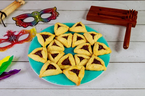 Jewish cookies Haman ears for Purim with mask and noisemaker. — Stok fotoğraf