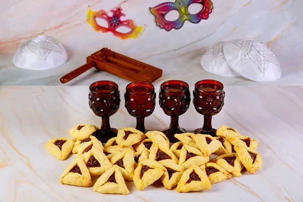 Tavolo da festa Purim con vino, biscotti, kippa, silenziatore e maschere . — Foto Stock