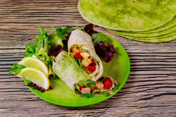 Wrap with grilled chicken and vegetable on plate with green salad and lemon. — Stock Photo, Image