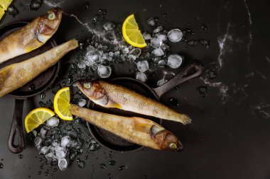 Siyah masada buzlu ve limonlu pişirilmemiş balık..
