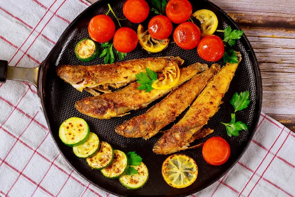 黒いフライパンで野菜やレモンで揚げたおいしい魚 魚介類コンセプト — ストック写真