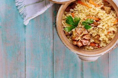 Sebzeli Çin pilavı ve ahşap zemin üzerinde kil çömlekte et..