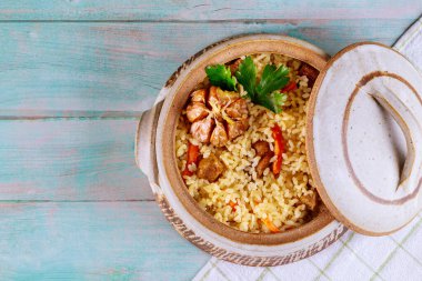 Sebzeli Tayland pilavı ve ahşap kapaklı tencerede et..