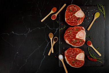 Baharat ve otla birlikte üç parça çiğ biftek. Üst görünüm.