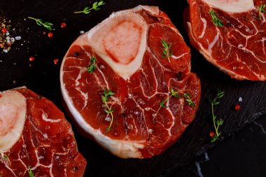 Baharat ve otla birlikte üç parça çiğ biftek. Kapat..