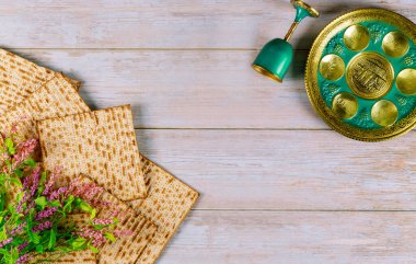 Yahudi matzası, şarap bardağıyla çocuk, İbranice yumurta, kemik, şifalı otlar, karpalar, chazeret ve charoset ile yemek. Hamursuz Bayramı konsepti.