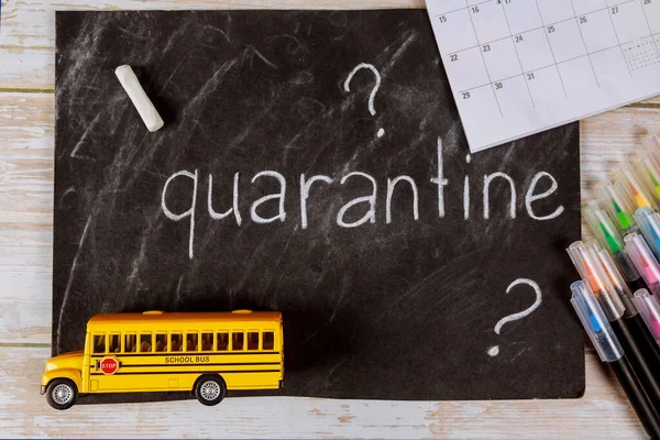 School bus toy and chalkboard with calendar. Quarantine concept.