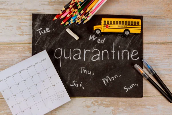 School bus toy and chalkboard with calendar. Quarantine concept.