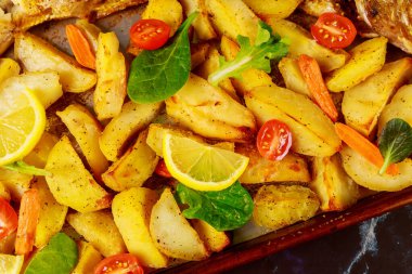 Fırında patates ve taze domates ve limon. Kapat..
