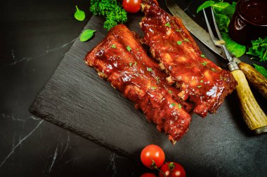 Siyah taş tahtada barbekü soslu domuz pirzolası. Kopyalama alanı olan üst görünüm
