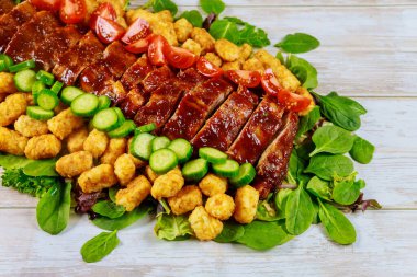 Izgara kaburga, yeşil salata, patates ve domates..