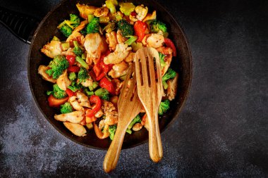 Lezzetli sağlıklı kızartılmış sebzeler ve tavuklu karanlık yüzey..