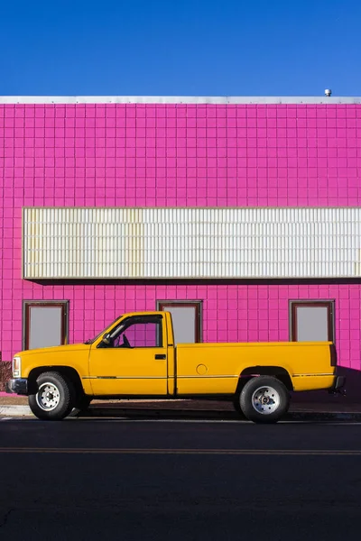 Ein Gelber Lkw Vor Einem Knallrosa Kino — Stockfoto