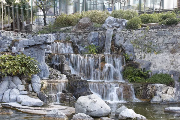 Big rock waterfall into tropical garden