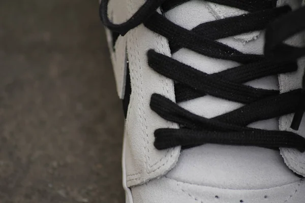 Man with black shoelaces tied together. white sneakers — Stock Photo, Image