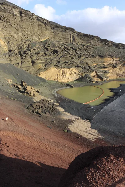 Groene meer op het eiland Lanzarote met vulkanisch zwart en rood zand in de buurt van de Atlantische Oceaan — Stockfoto