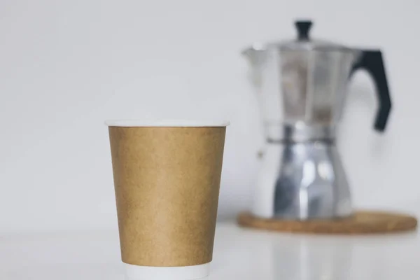 Переработка коричневой чашки и серебристый кофе машина на белый стол — стоковое фото