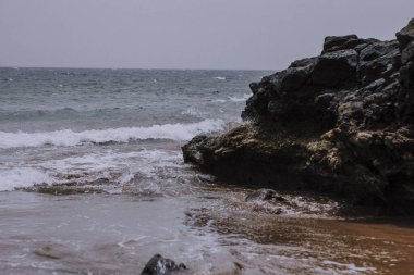 Atlantik Denizi 'nde volkanik kayaların üzerinde balık tutan balıkçılar.