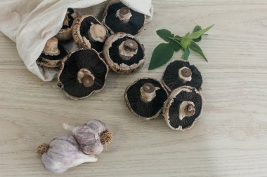 Taze mantar şampiyonu geri dönüşüm torbasında sarımsak ve bazilikle