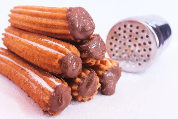 Beyaz arka planda çikolata sosuyla doldurulmuş Churros.