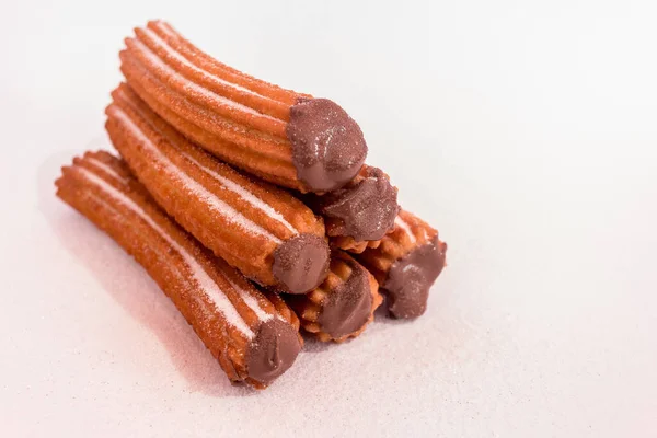 Beyaz arka planda çikolata sosuyla doldurulmuş Churros.