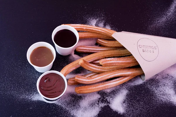 Şeker, karamel, koyu ve sütlü çikolata soslu Churros.