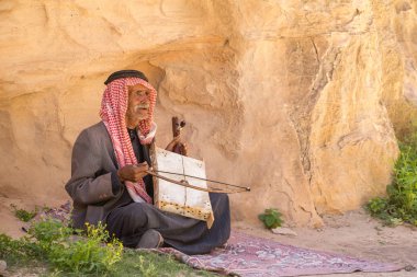Petra, Ürdün - 29 Nisan 2016: Yaşlı Bedevi adamla onun kendi kendine yapılan müzik enstrümanı